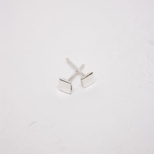 A pair of silver square stud earrings on a white background.