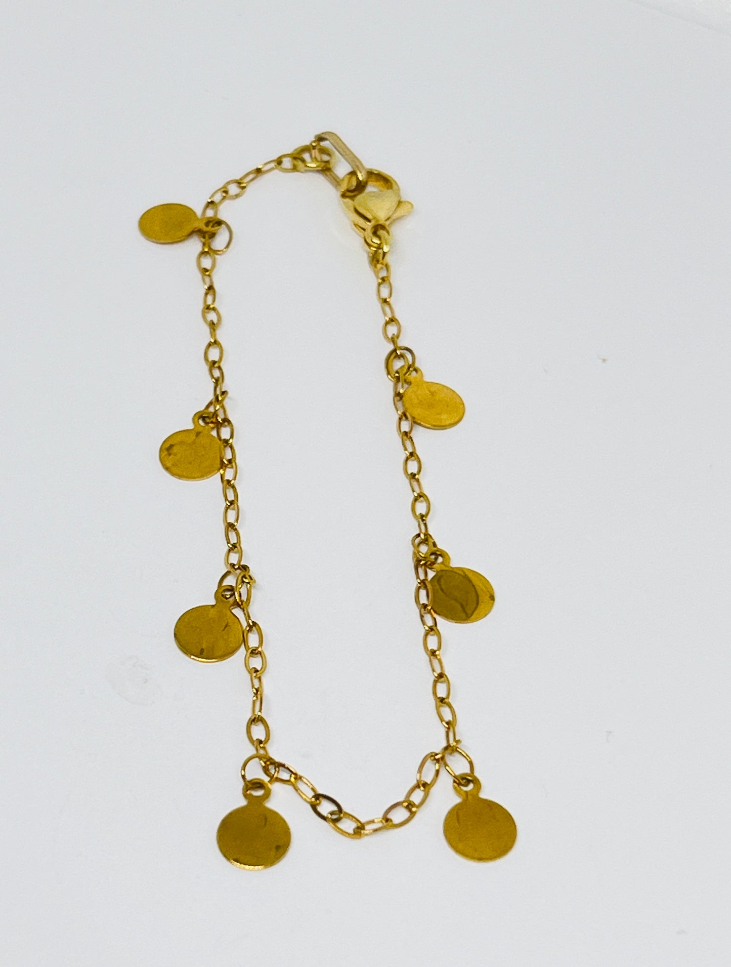 Adorned with tiny golden pendants that delicately dangle and catch the light with every step you take, this anklet is perfect for adding a touch of sparkle to any outfit. 
