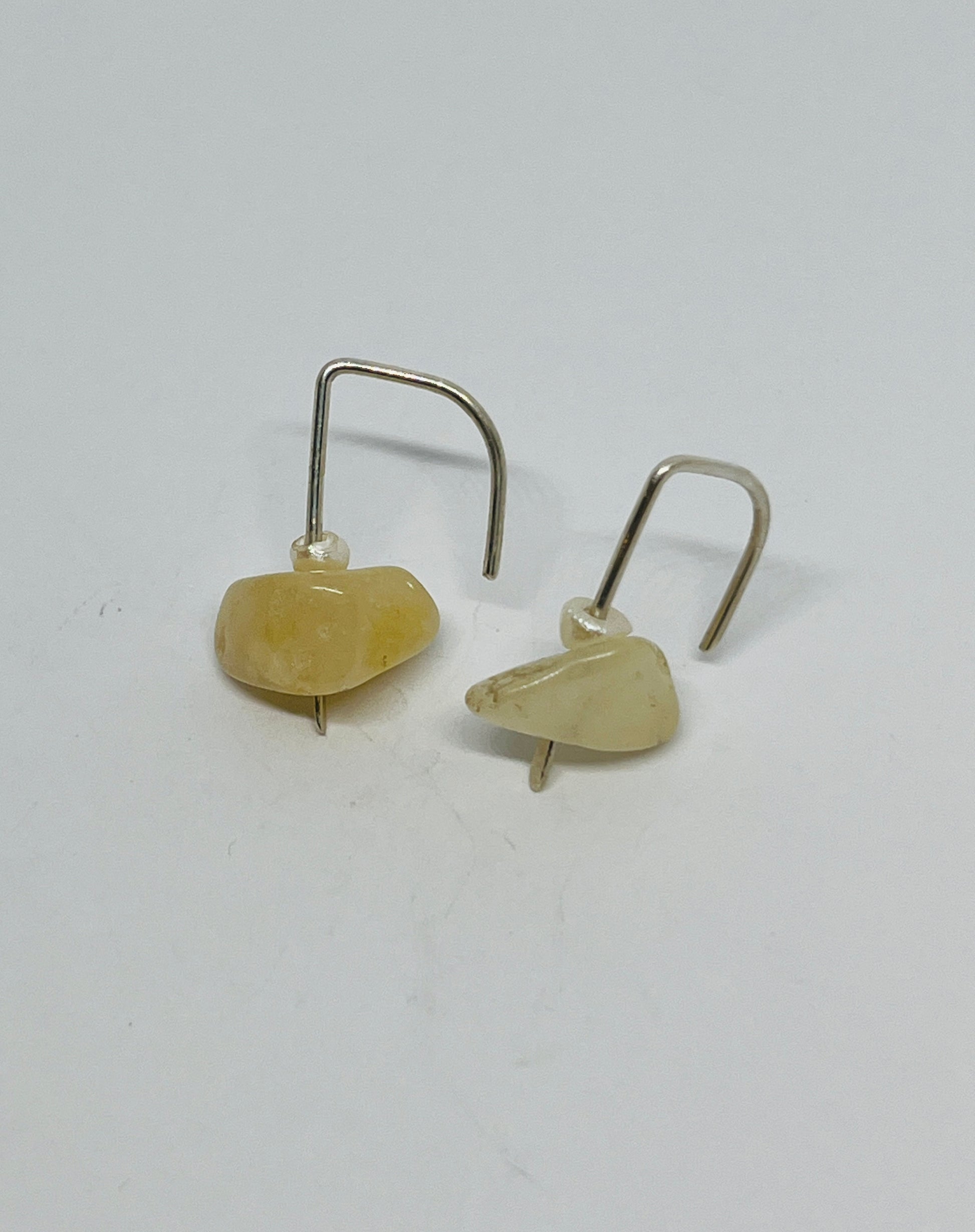 a luxurious pearl suspended alongside a striking ember natural stone, elegantly dangling from sterling silver posts. Each element in this design embodies the essence of empowerment and the enduring spirit within every woman.