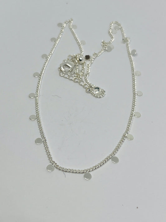 Silver necklace with circular pendants on a light gray background