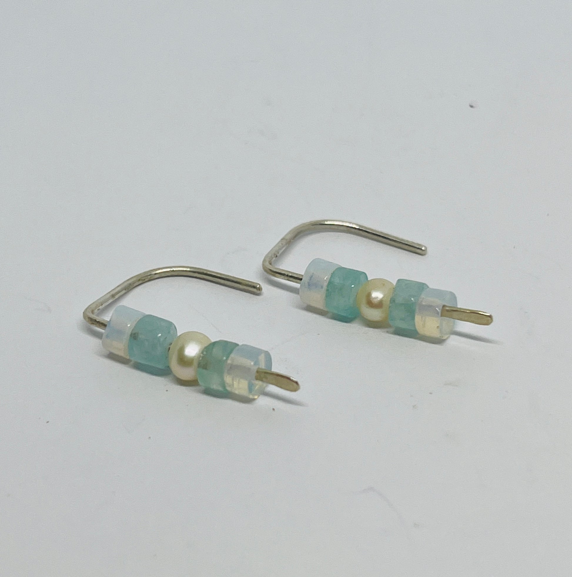 handcrafted earrings are a quiet homage to the elements — combining the gentle glow of moonstone, the clear calm of aquamarine, and the timeless grace of freshwater pearl. Suspended from sterling silver in a unique dangle form, each element moves with you, like ripples on water or moonlight on skin.