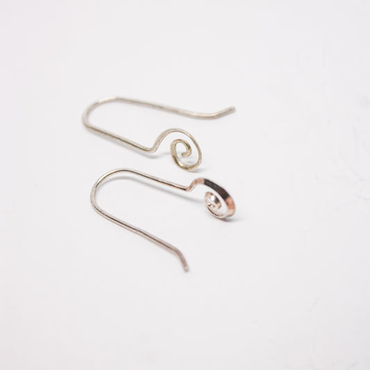 A pair of silver dangle earrings with a spiral design, displayed against a white background.